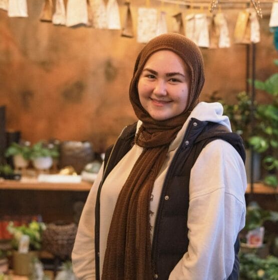 Eine Frau mit Hijab steht in einem Blumenladen.